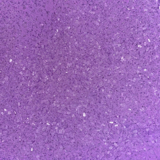 Close-up of fine, bright purple bath soak crystals with a slightly coarse texture and a sparkly, granular appearance