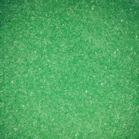 Close-up of fine, bright green bath soak crystals with a slightly coarse texture and a sparkly, granular appearance