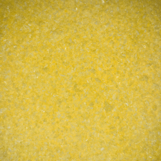 Close-up of fine, bright yellow bath soak crystals with a slightly coarse texture and a sparkly, granular appearance